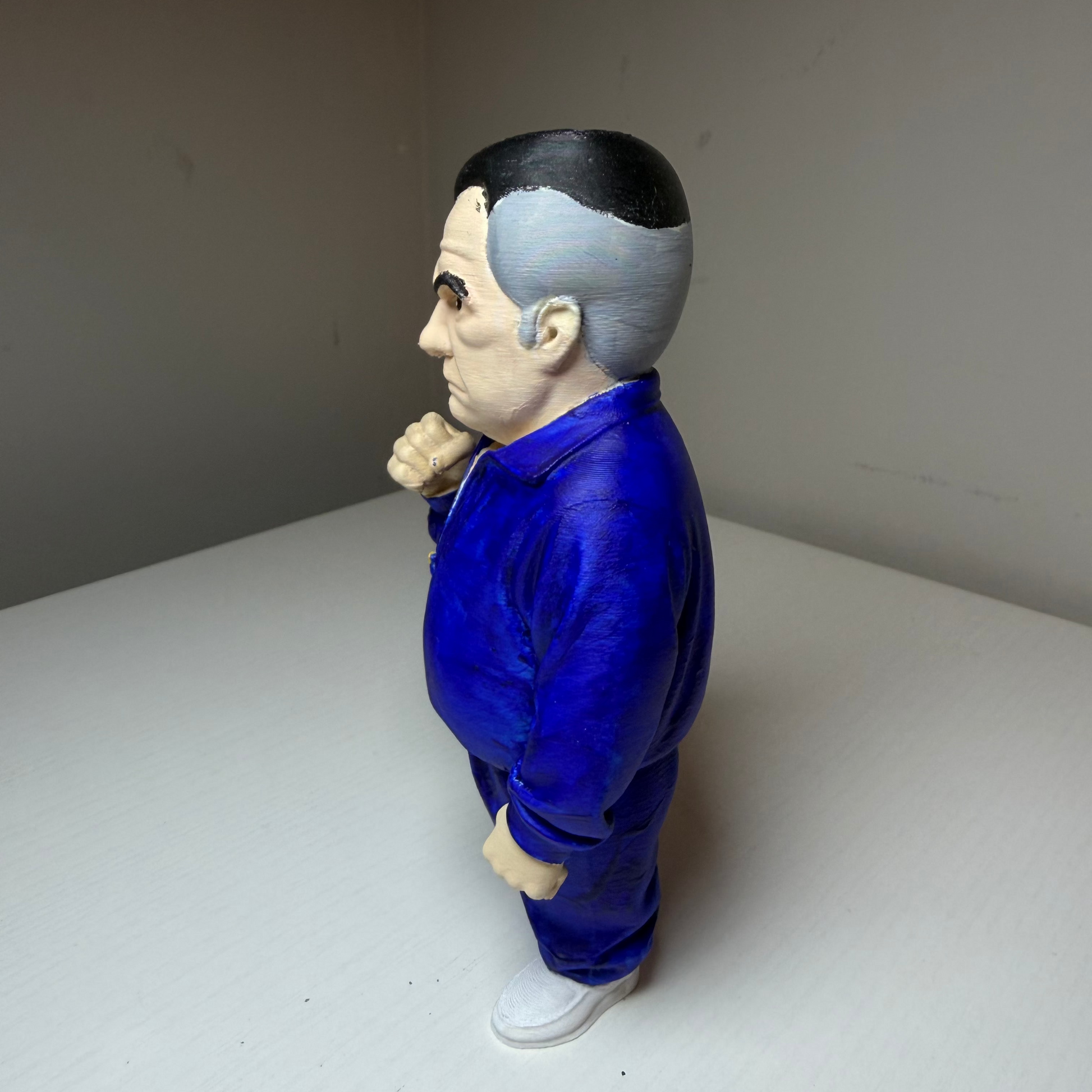 Paulie Walnuts Action figure from The Sopranos in a blue tracksuit on a plain background