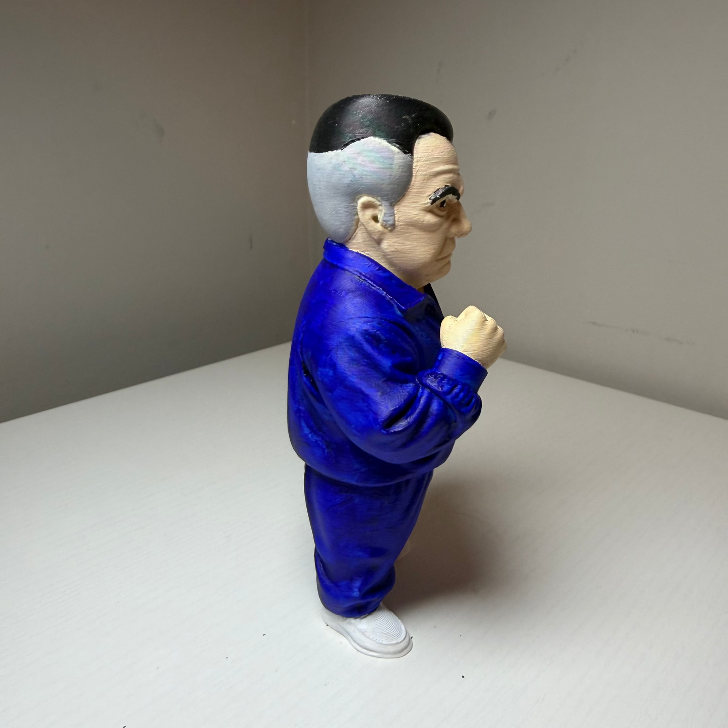 Paulie Walnuts Action figure from The Sopranos in a blue tracksuit on a plain background